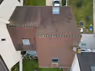 Vue aérienne d’une maison dont la couverture est noircie par la mousse