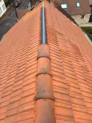 Faîtage neuf posé sur une couverture en tuiles rouges, closoir ventilé visible